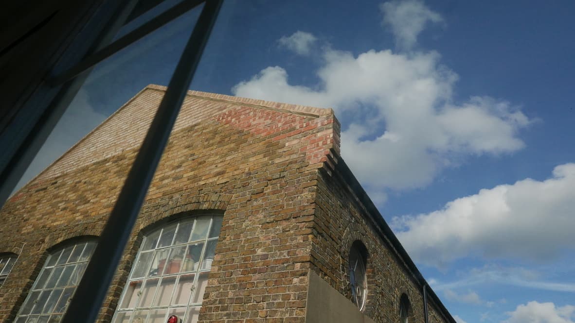 Floor-to-ceiling industrial windows providing natural diffused light for professional photography at Good Mews Studio